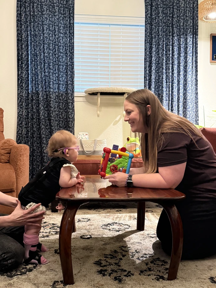 Marley Anne standing at a table, playing with her mom