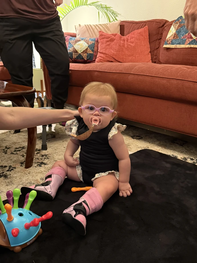 Marley Anne sitting up on her own, surrounded by toys